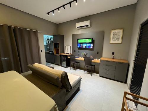 a living room with a couch and a desk and a television at Studio Casa21 - Moderno e aconchegante in Cáceres