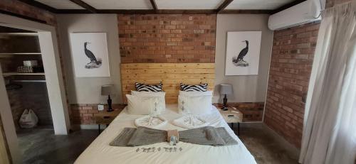 a bedroom with two beds in a brick wall at Singwe Private Safari Lodge Kruger in Marloth Park