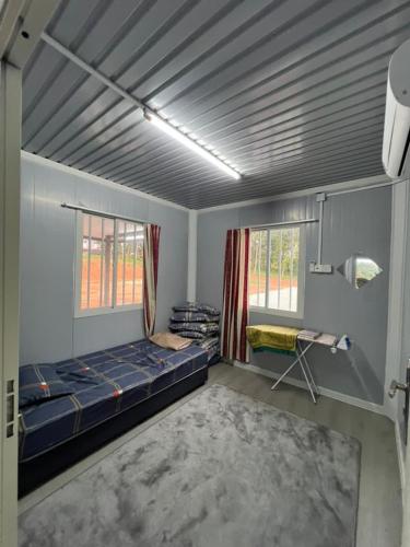a room with a blue bed and two windows at Homestay D'Pengkalan in Masjid Tanah