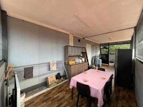 a kitchen with a pink table and chairs in a room at Homestay D'Pengkalan in Masjid Tanah