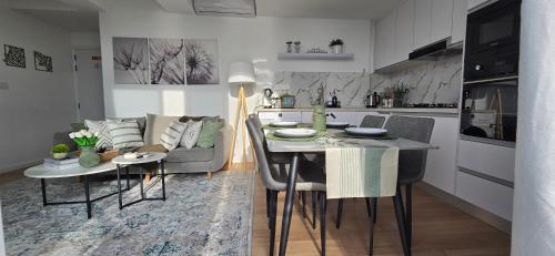 a kitchen and living room with a table and a couch at Nala Host- 2BR Beachfront Apartment in Male City