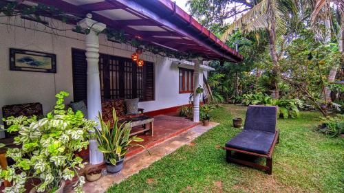 une terrasse couverte d'une maison avec une chaise et des plantes dans l'établissement Beach House Madiha, à Matara