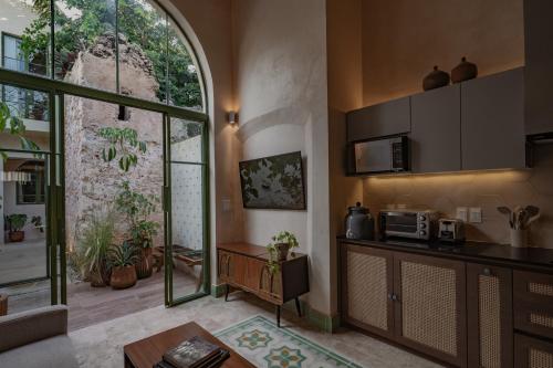 a living room with a kitchen with a large window at Casa Pistache, colonial hideout in Campeche