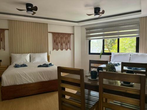 a bedroom with a bed and a table and chairs at Inngo Tourist Inn in El Nido