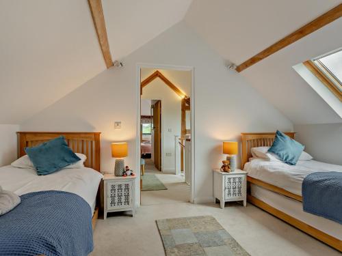 a bedroom with two beds and a mirror at 5 Bed in Exebridge 41133 in Brushford