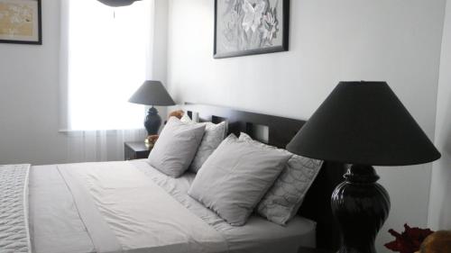 a bedroom with a white bed with a black lamp at Boyd Apartments in Staten Island