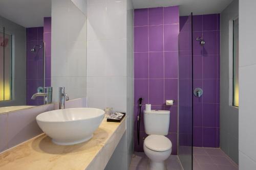 a bathroom with a sink and a toilet and a shower at Avery Kusumanegara Yogyakarta in Demangan