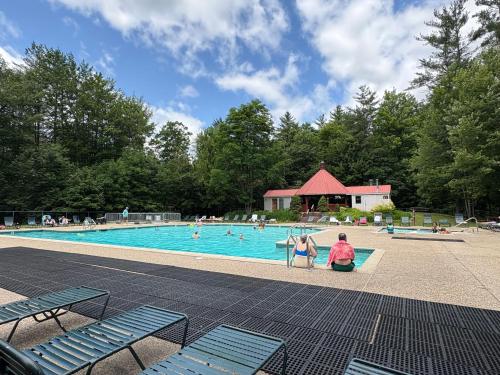 a group of people sitting in a swimming pool at Cozy Attitash Getaway-1BR-Pool-Walk to Attitash in Bartlett