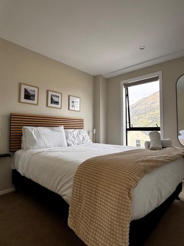 a bedroom with a large bed with a window at Queenstown Retreat in Queenstown