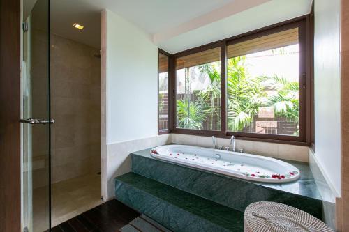 eine Badewanne im Bad mit Fenster in der Unterkunft Katamanda Villa Allegra 5 bedroom Seaview villa in Kata Beach