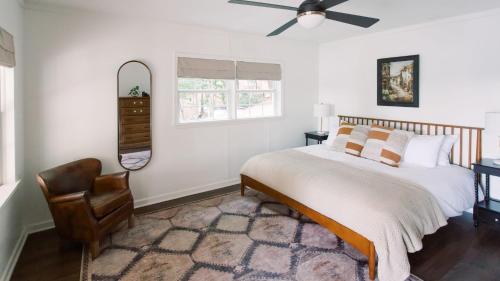 a bedroom with a bed with a fan and a chair at Hummingbird Home by AvantStay Boat House Dock in Statesville