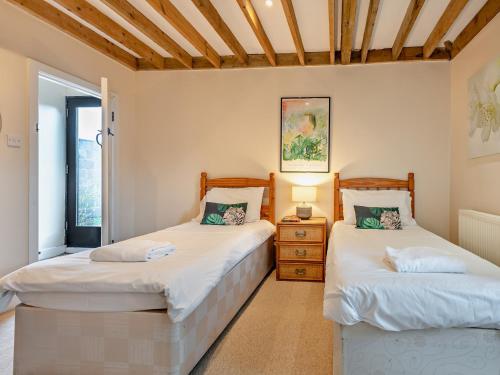 two twin beds in a room with a window at 2 Bed in Sedgehill 96237 in Sedghill