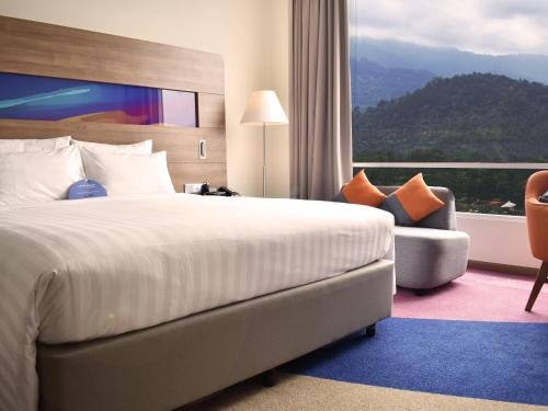 a hotel room with a large bed and a window at Novotel Taiping in Taiping