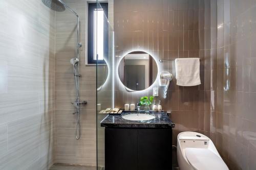 une salle de bain avec un lavabo et une douche avec un miroir dans l'établissement Dương Villa, à Hội An