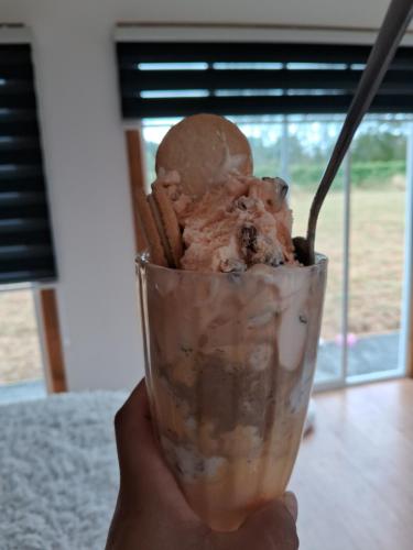 une main tenant une tasse de glace au chocolat dans l'établissement La tiny de cuinco, à La Unión