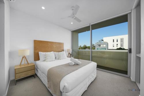 a bedroom with a bed and a large window at Mowbray East Apartments in Brisbane
