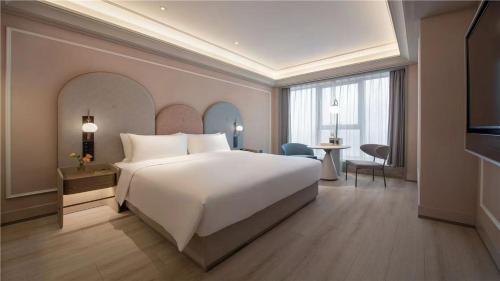 a large white bed in a hotel room at Mercure Suzhou Shilu Shantang in Suzhou