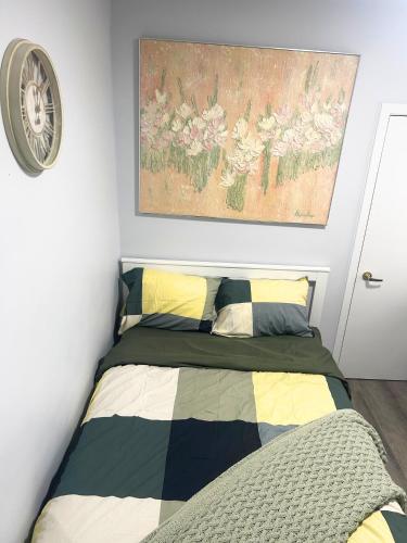 a bedroom with a bed and a painting on the wall at Cozy Private Room Near Downtown Toronto in Toronto
