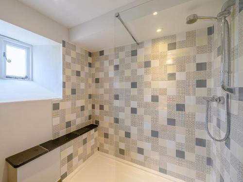 a bathroom with a shower with tiled walls at 1 Bed in High Bickington 55321 in High Bickington