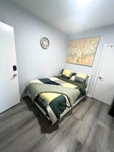 a bedroom with a bed with a clock on the wall at Cozy Private Room Near Downtown Toronto in Toronto
