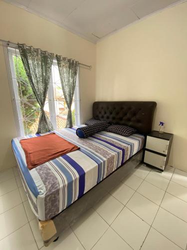 a bed in a bedroom with a window at Villa Fathan in Tjiandjur