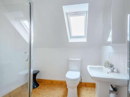 a white bathroom with a toilet and a sink at 1 Bed in Kinlochbervie 86897 in Rhiconich