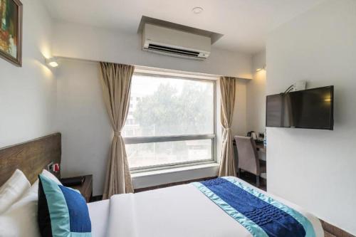 a hotel room with a bed and a window at Palette - Silver Leaf in Vapi