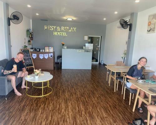 een paar mensen aan tafel in een restaurant bij Rest And Relax Hostel in Ban Mo Nae