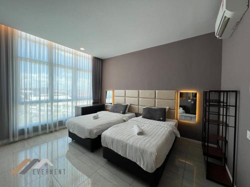 a bedroom with two beds and a large window at Suites Homestay by Evernent in Miri