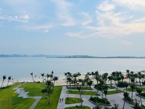 下龙湾A La Carte Hạ Long- Little Kun Homestay的享有棕榈树海滩和水域的景色