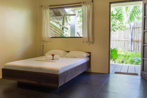a bedroom with a bed and a large window at Buddha Resort in Catagnan
