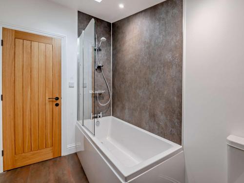 Tollertonにある3 Bed in Tollerton 93897の白い浴槽とシャワー付きのバスルーム