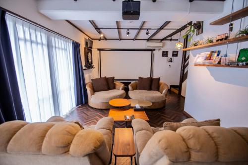 a living room with two couches and a large window at Cinema Resorts 1 in Motobu