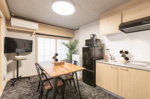 a kitchen with a table and a black refrigerator at b&黒門1号店 in Osaka