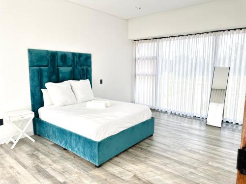 a bedroom with a large bed with a blue headboard at Sucassa 54 - Luxury 2 Bedroom - Dam & Mountain View in Hartbeespoort