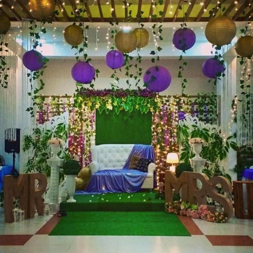 a room with purple and green decorations and a couch at AGM Beachfront Resort in Donsol
