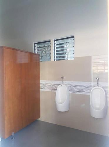 a bathroom with two urinals on a wall at AGM Beachfront Resort in Donsol
