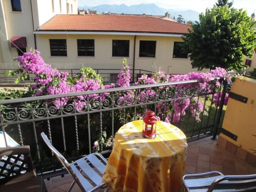 a table and chairs on a balcony with purple flowers at The Queen Tower in Desenzano del Garda