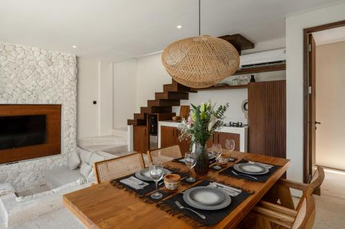 a dining room with a wooden table with chairs and a dining room at La Finca Bingin in Uluwatu