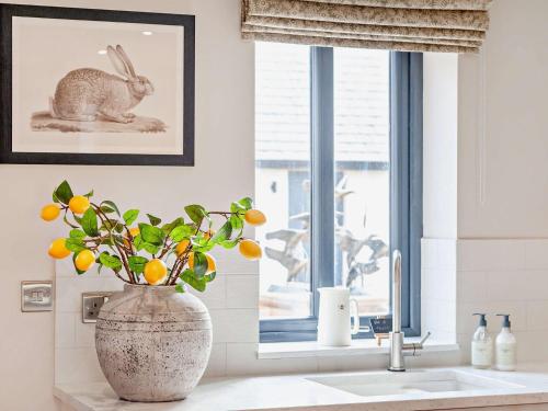 a bathroom sink with a vase with a plant in it at 2 Bed in Talkin 91822 in Brampton