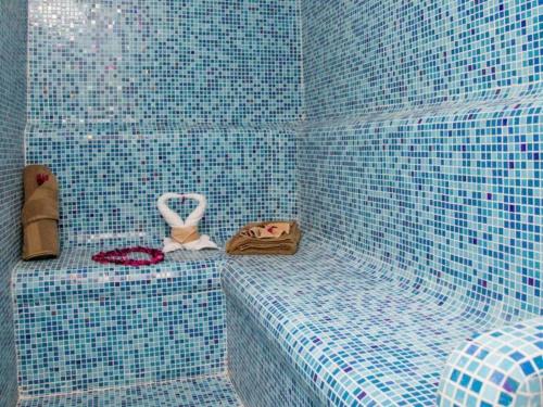 a bathroom with blue tiled walls and a shower at Gulf Pearls Hotel in Doha