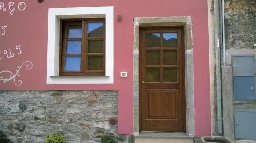 una casa rosa con dos ventanas y una puerta en Il Borgo Di Pegui en Bolano