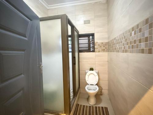 een badkamer met een toilet met open deur bij Spacious Modern 3-Bedroom Foxdale in Foxdale Estates