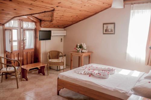 1 dormitorio con 1 cama y TV en una habitación en Metin Hotel en Dalyan