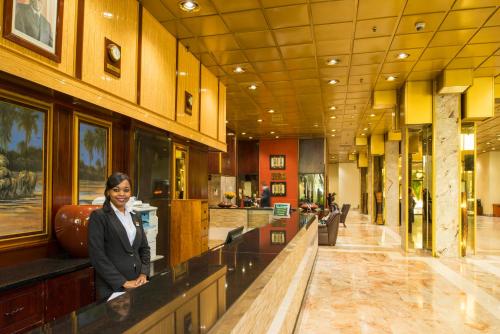 a woman standing at a counter in a lobby at Rainbow Towers Hotel & Conference Centre in Harare