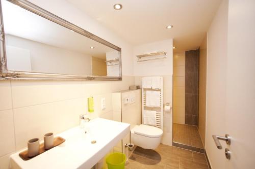 a bathroom with a sink and a toilet and a mirror at Hotel Vintage Am Bundesbank-Bunker in Cochem