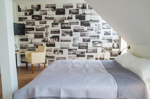 a bedroom with a wall covered in black and white photos at Pokoje na Szlaku Kajki 20A in Mikołajki