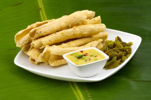 a plate of food with dip and green beans at Flagship The Address in Deolāli