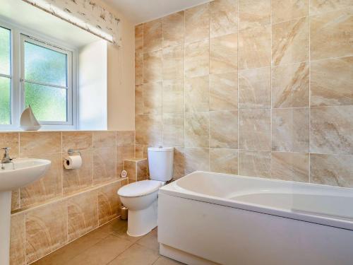 a bathroom with a toilet and a tub and a sink at 4 Bed in Dorchester 92413 in Frome Vauchurch