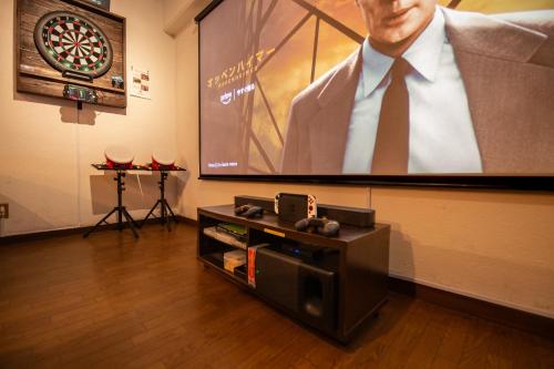 a flat screen tv sitting on a wall next to a entertainment center at Cinema Resorts 3 in Motobu